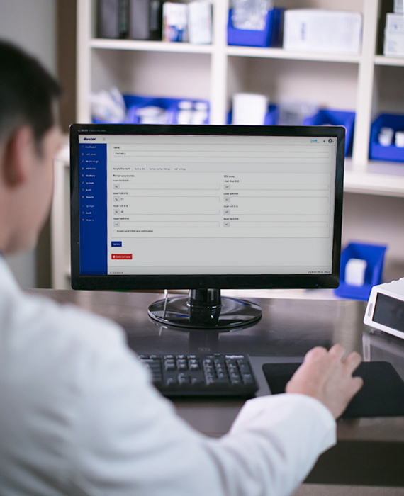 A tablet being held by a pharmacist that is showing data.